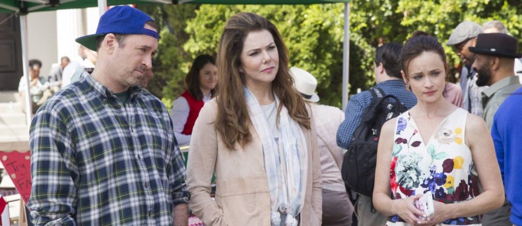 Luke, Lorelai e Rory olham espantados para alguma coisa. 